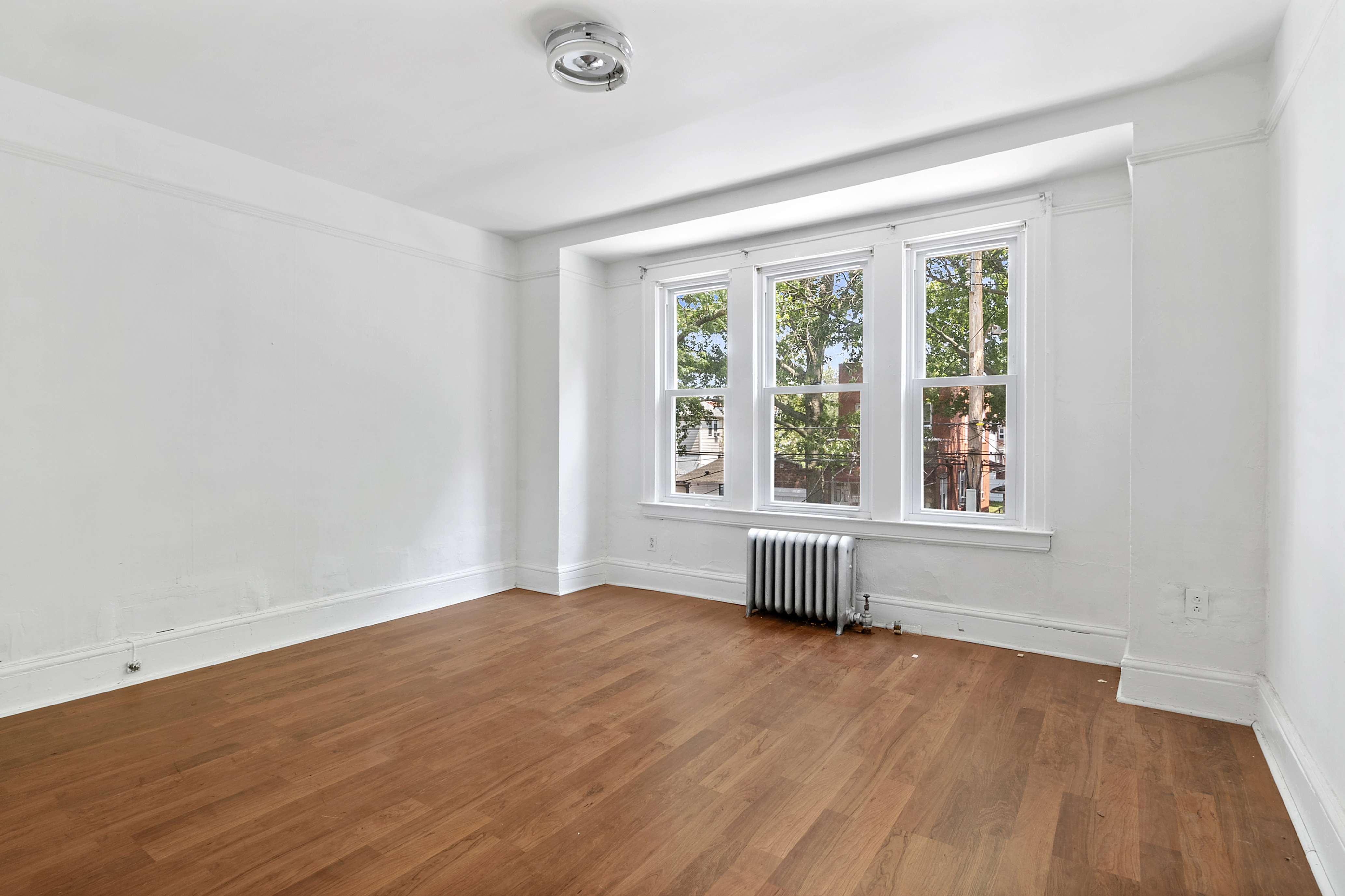 266 East 43rd Street Brooklyn, NY 11203 - Photo 8 of 11 an empty room with wooden floor and windows