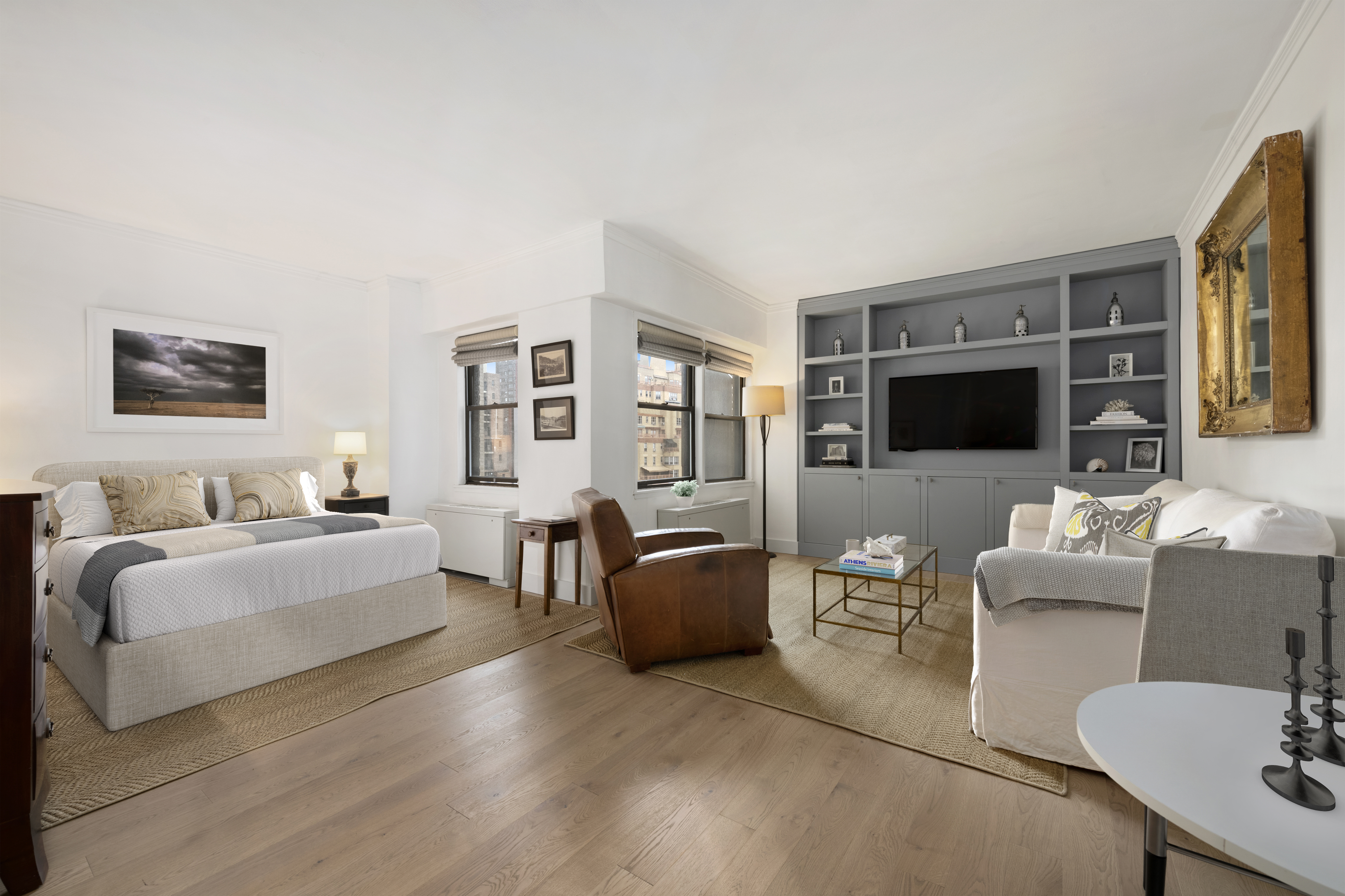 201 East 21st Street, Unit 12M Manhattan, NY 10010 - Photo 2 of 10 a living room with furniture flat screen tv and large window
