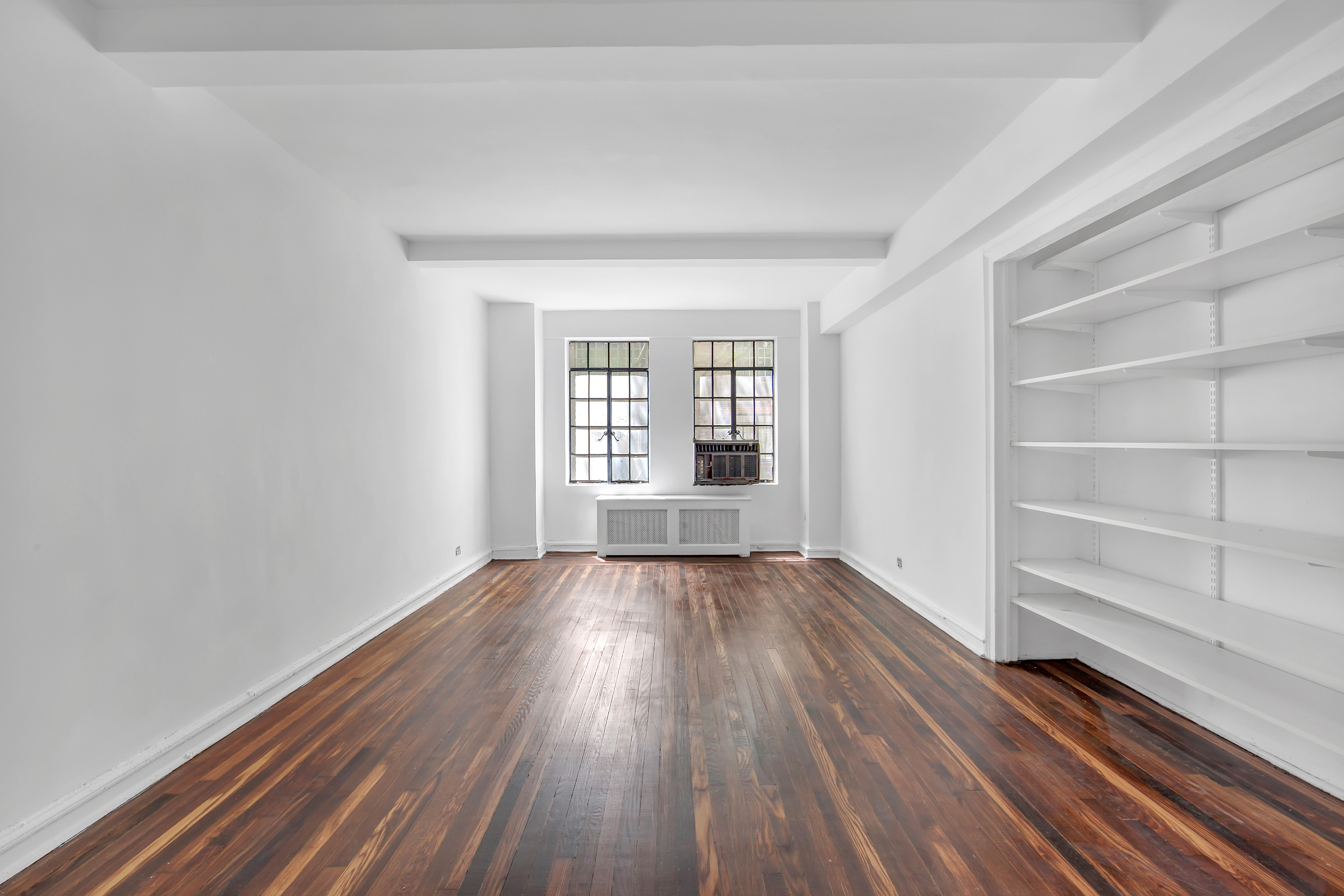 320 East 42nd Street, Unit 516 Manhattan, NY 10017 - Photo 2 of 11 wooden floor in an empty room with a window