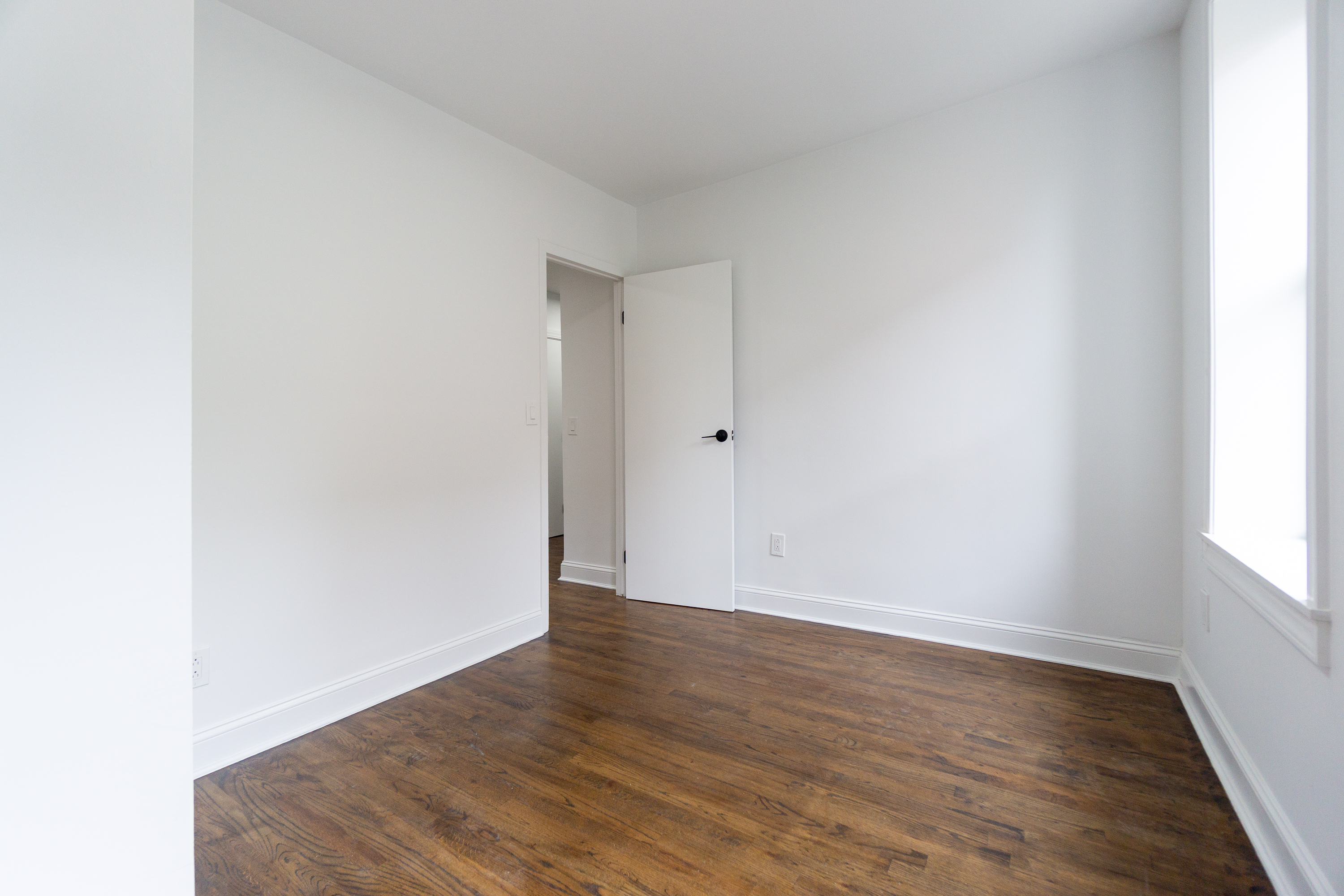 342 East 6th Street, Unit 3 Manhattan, NY 10003 - Photo 7 of 13 a view of an empty room with wooden floor and a window