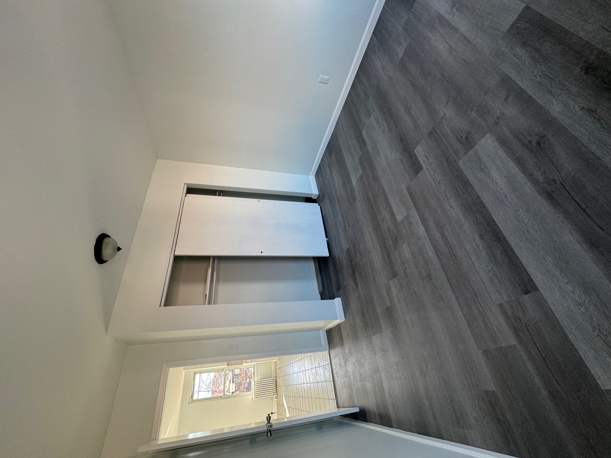 89-16 102nd Road, Unit 2 Queens, NY 11416 - Photo 9 of 13 a view of an empty room with wooden floor and a window