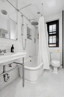 a bathroom with a toilet sink a mirror and shower