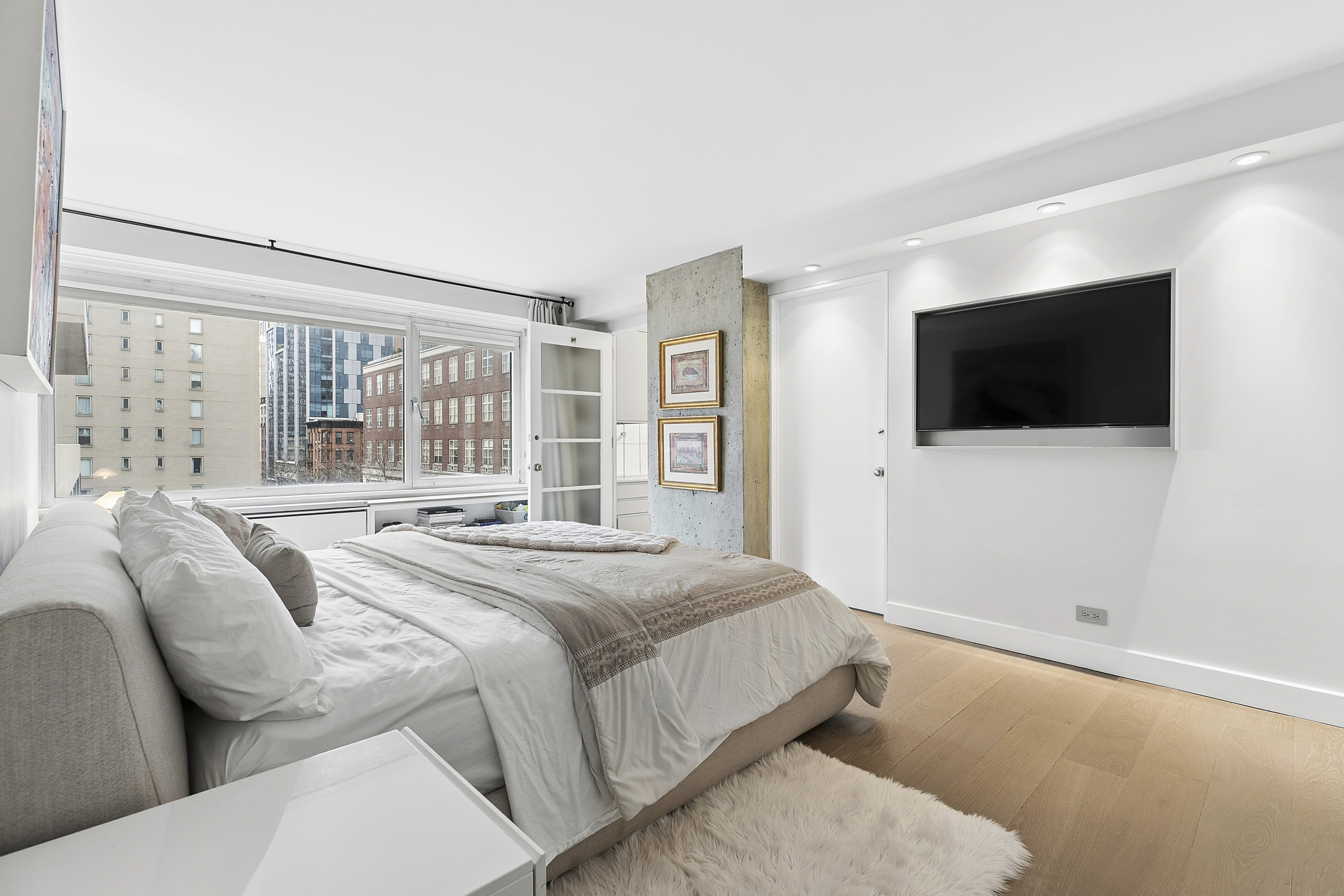 1065 Park Avenue, Unit 4BC Manhattan, NY 10128 - Photo 6 of 16 a bedroom with a bed a tv and a large window