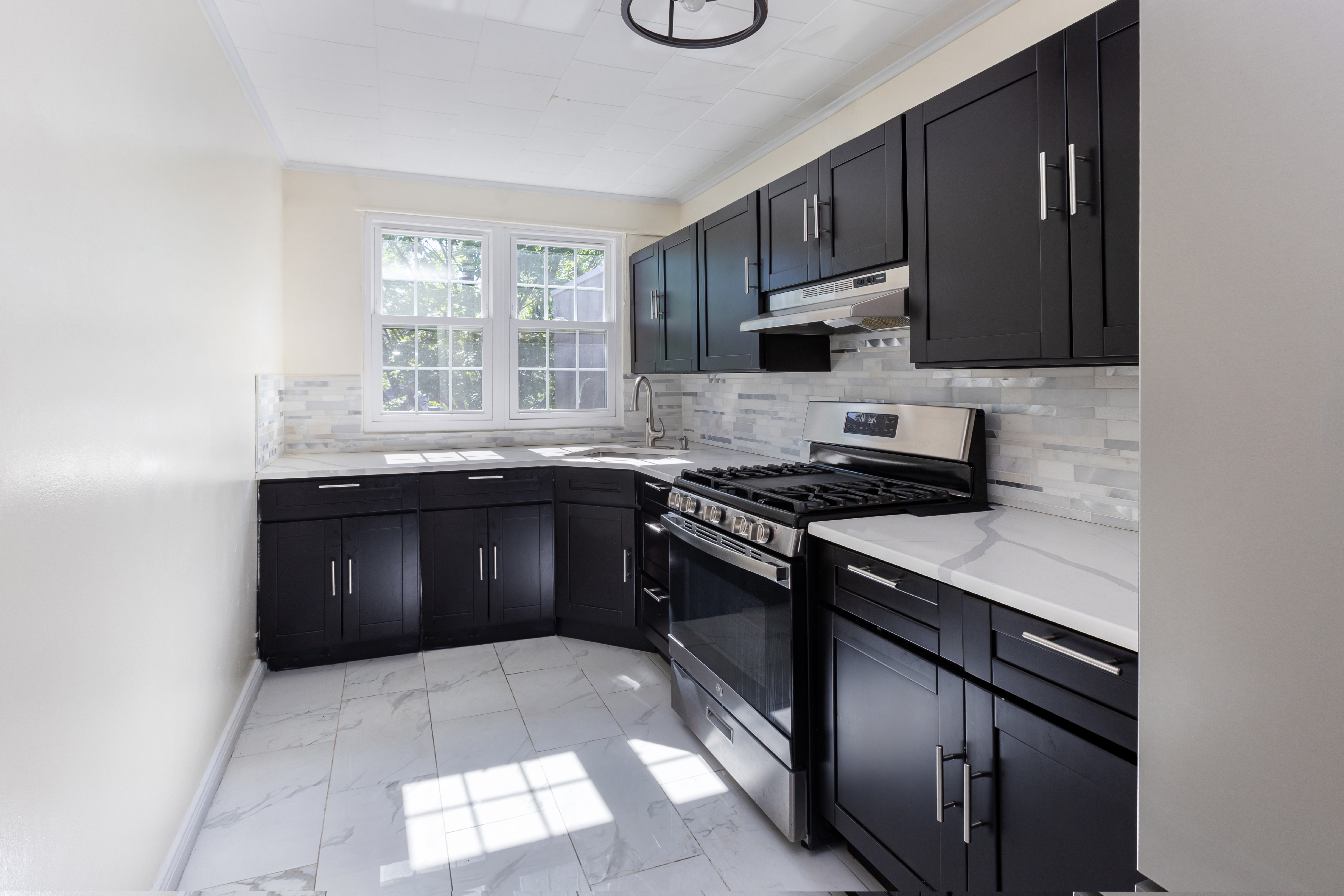 4167 Bruner Avenue Bronx, NY 10466 - Photo 10 of 16 a kitchen with granite countertop a stove sink and cabinets