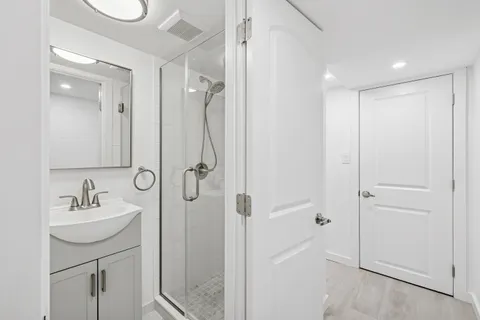 a bathroom with a double vanity sink a mirror and a shower
