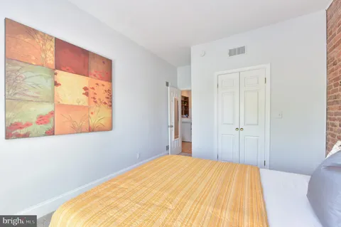 a bed room with a bed and a painting on the wall