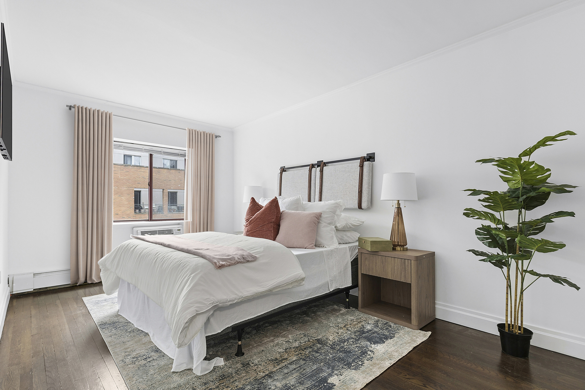 217 East 7th Street, Unit 5CD Manhattan, NY 10009 - Photo 5 of 11 a bedroom with a large bed and a potted plant