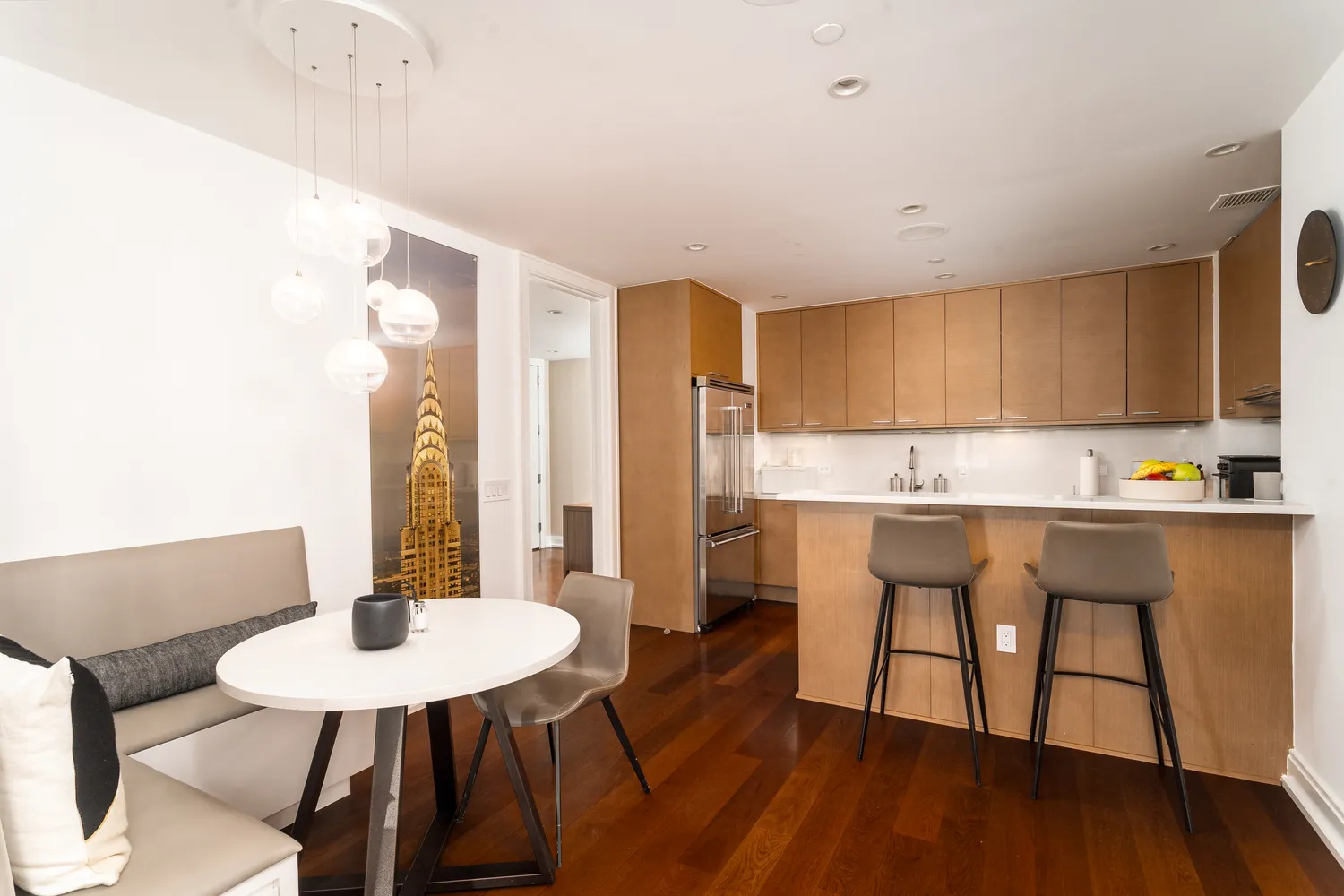 a kitchen with stainless steel appliances a dining table chairs and a refrigerator