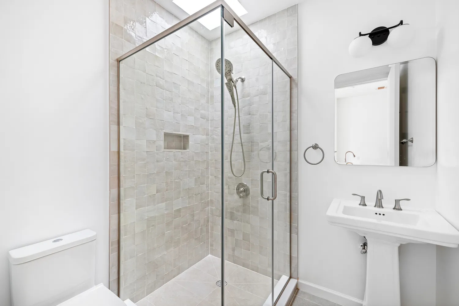 a bathroom with a shower sink and mirror
