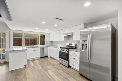 a kitchen with sink cabinets and wooden floor