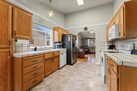 a kitchen that has a lot of cabinets in it and wooden floors