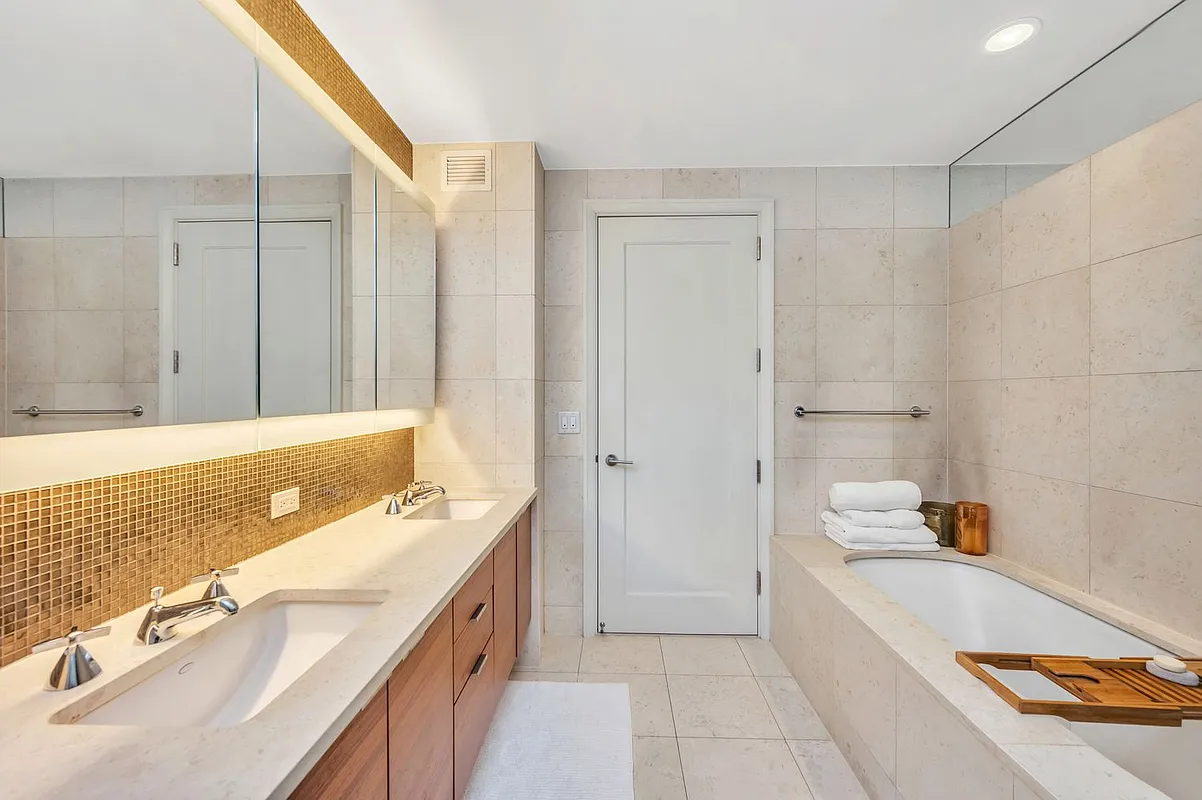70 Little West Street, Unit 15A Manhattan, NY 10004 - Photo 10 of 19 a spacious bathroom with a tub sink and mirror