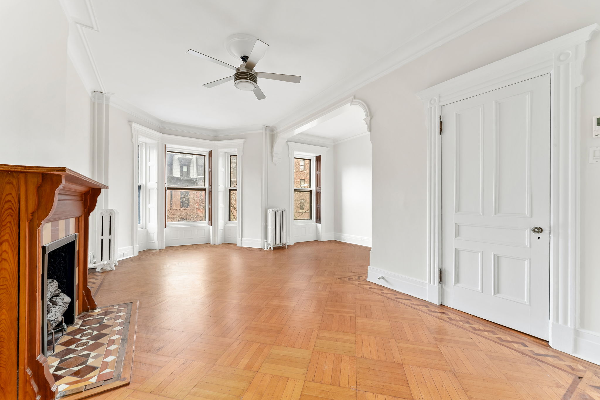 694 10th Street, Unit 2 Brooklyn, NY 11215 - Photo 7 of 22 a view of an empty room with chandelier fan and fire place