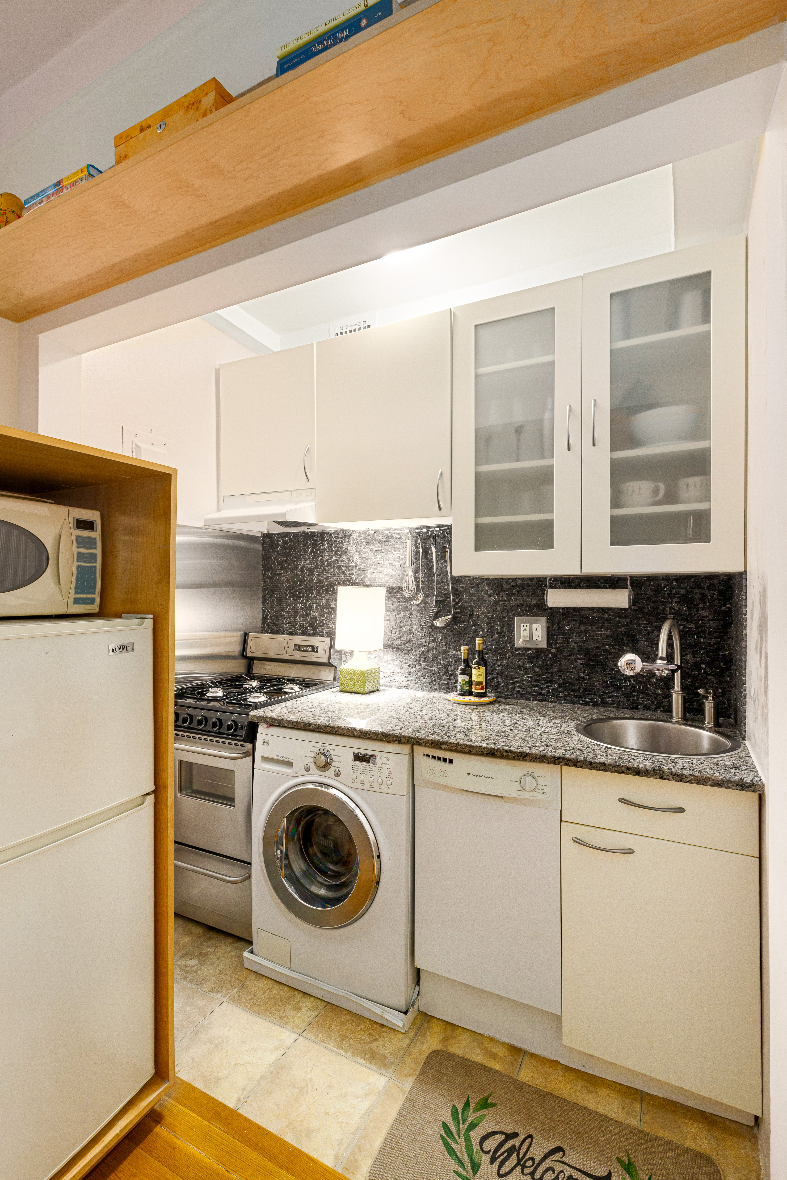 225 Central Park West, Unit 416 Manhattan, NY 10024 - Photo 6 of 16 a kitchen with a stove top oven sink and cabinets