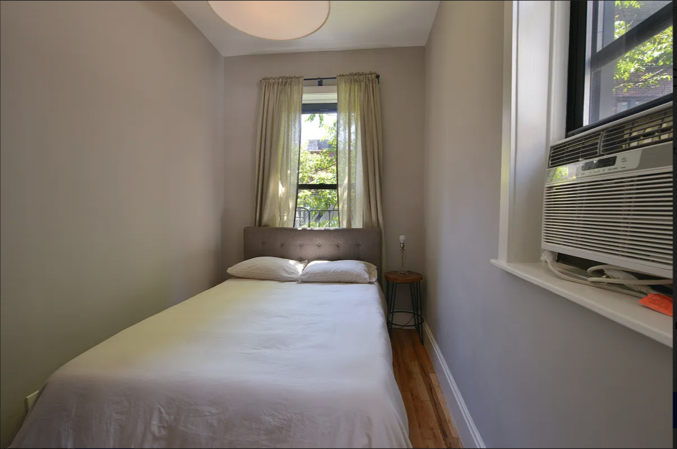 120 East 83rd Street, Unit 5C Manhattan, NY 10028 - Photo 5 of 8 a bedroom with a bed and a flat tv screen on dresser