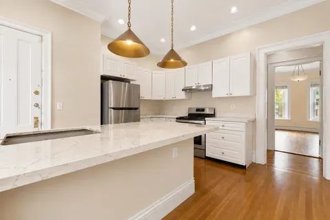 a kitchen with stainless steel appliances a stove a sink and a refrigerator