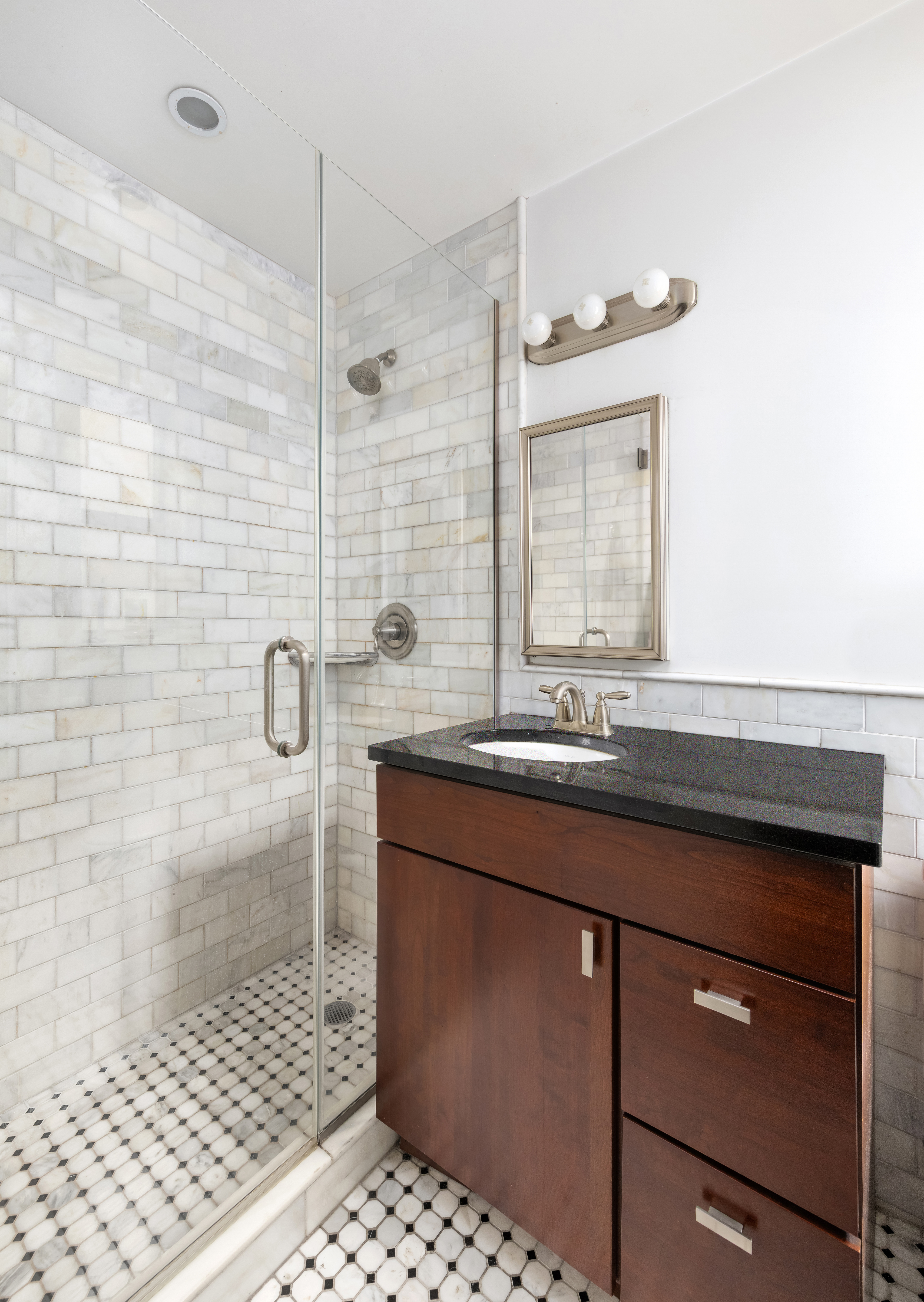333 East 43rd Street, Unit 110/111 Manhattan, NY 10017 - Photo 4 of 16 a bathroom with a sink a mirror and shower