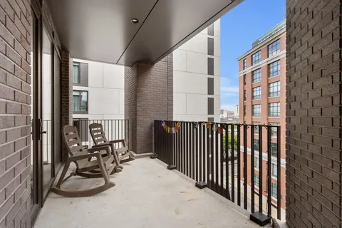 a balcony view with a couple of cars parked in parking lot