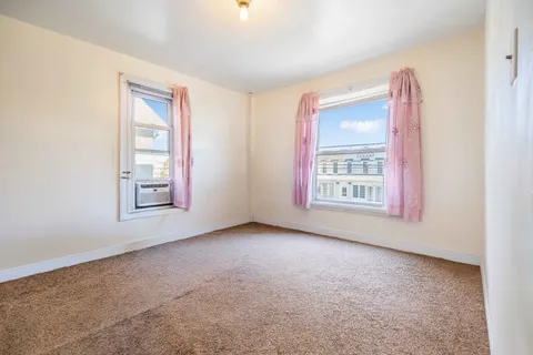 an empty room with windows and closet