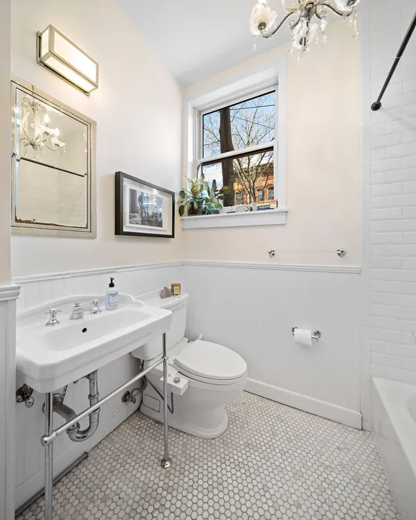 a bathroom with a toilet a sink and mirror