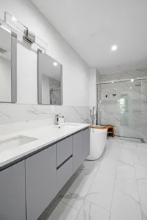 a bathroom with a granite countertop sink mirror and a bathtub