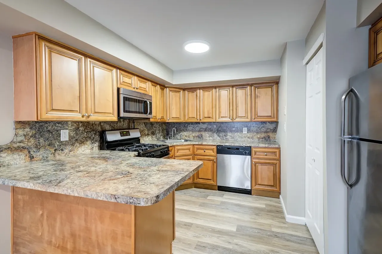 a kitchen with a refrigerator a stove a sink and a counter space