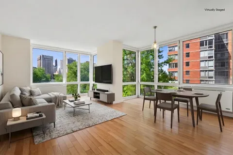 a living room with furniture a flat screen tv and a large window
