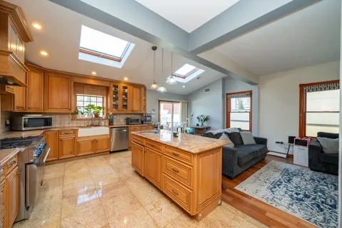 a large living room with stainless steel appliances granite countertop a couch and wooden floor