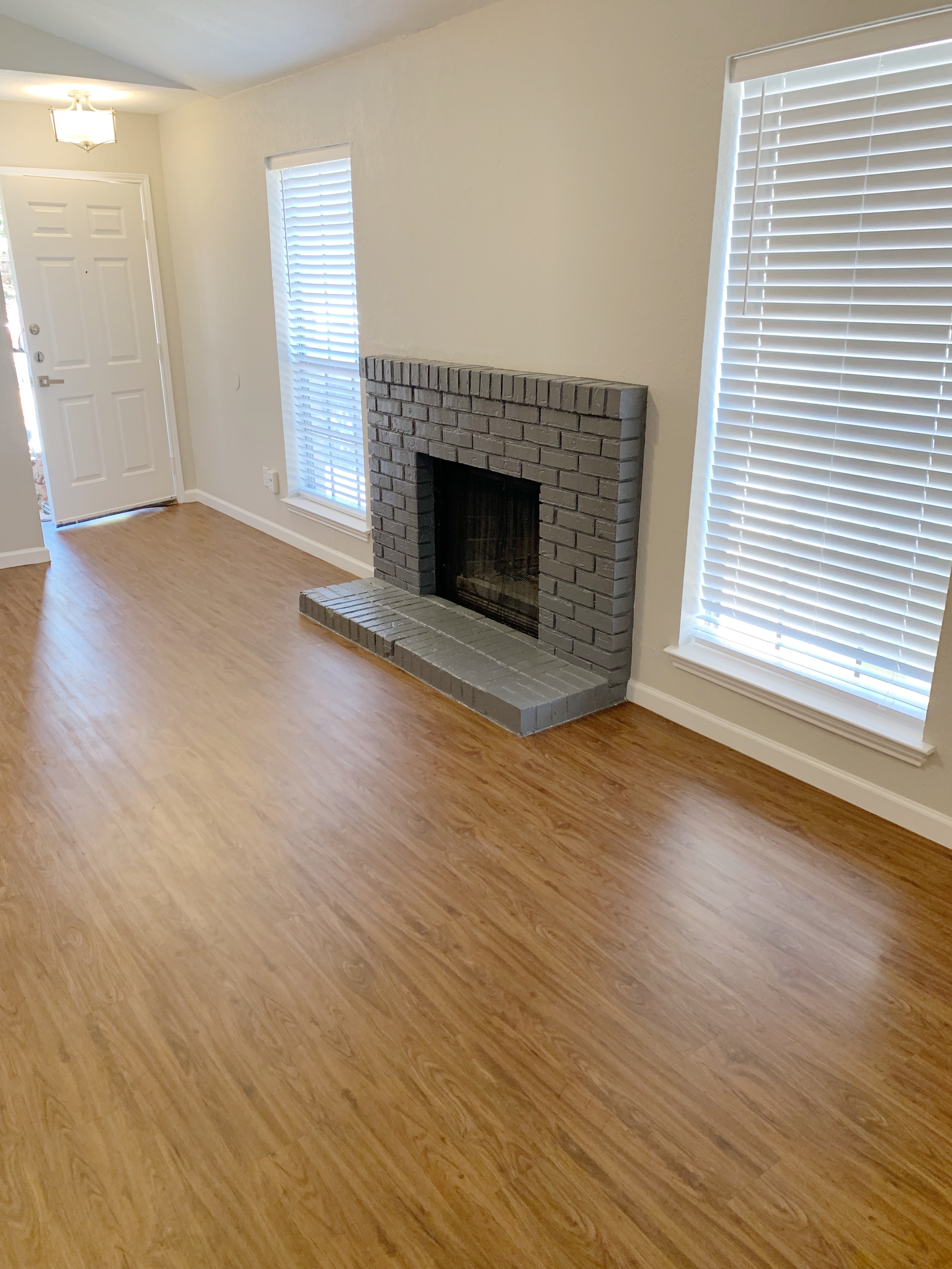 5708 Ranchogrande Drive Arlington, TX 76017 - Photo 2 of 3 an empty room with wooden floor fireplace and windows