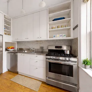 a kitchen with stainless steel appliances granite countertop a stove and white cabinets