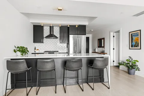a kitchen with a sink and chairs