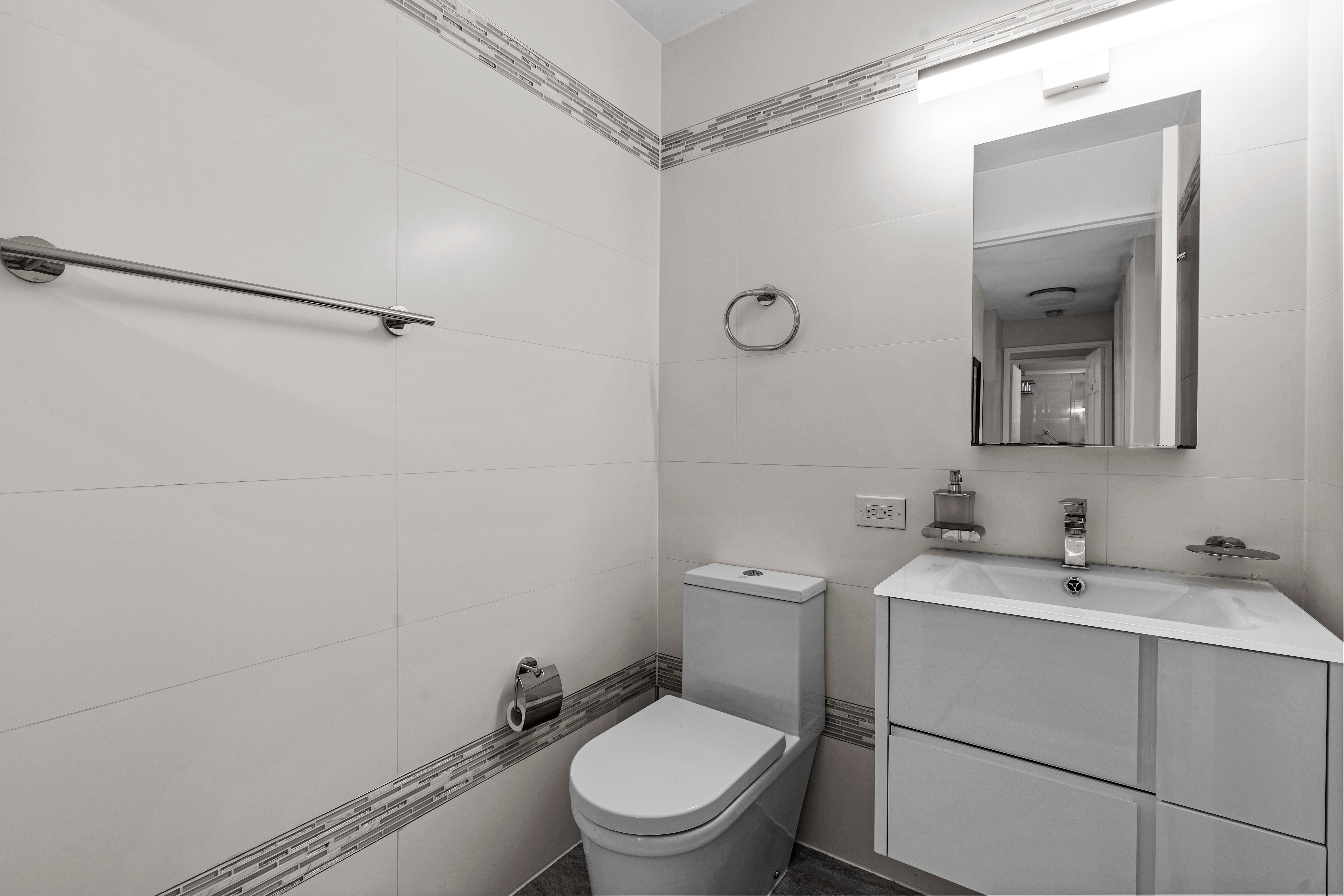 112-01 Queens Boulevard, Unit 7E Queens, NY 11375 - Photo 7 of 27 a bathroom with a toilet a sink and a mirror