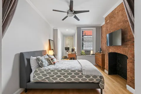 a bedroom with a large bed and a fireplace