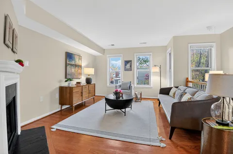 a living room with fireplace furniture and a wooden floor