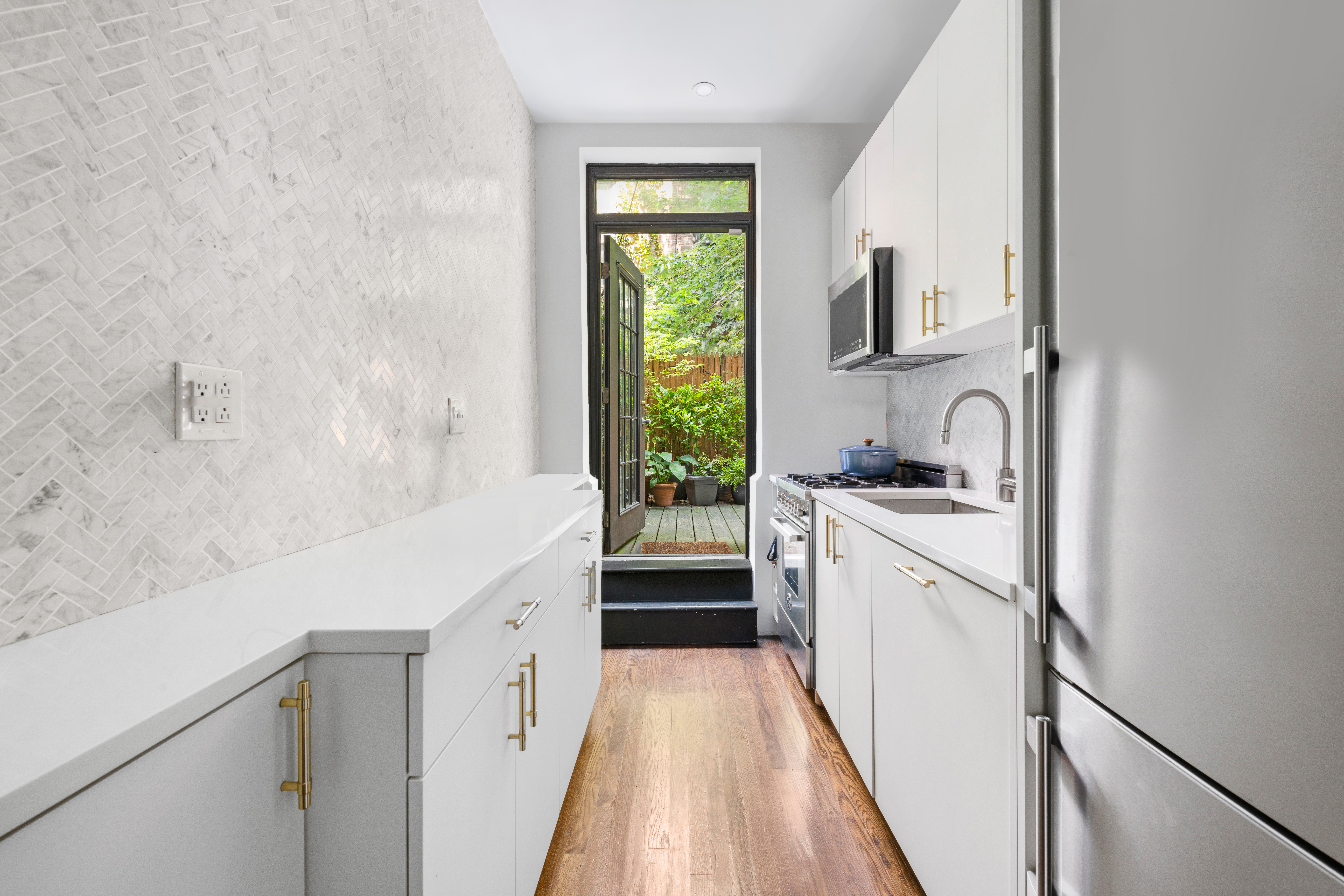 21 West 9th Street, Unit 1F Manhattan, NY 10011 - Photo 3 of 11 a kitchen with white cabinets and white appliances