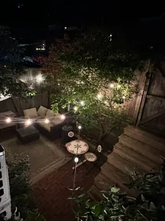 a backyard of a house with table and chairs with wooden floor