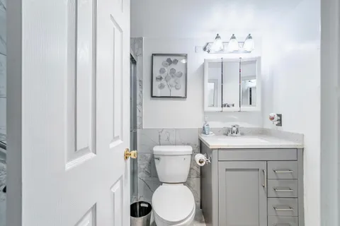 a bathroom with a toilet a sink and mirror