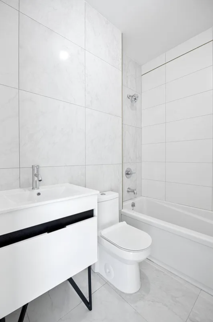 586 Marcy Avenue, Unit 3A Brooklyn, NY 11206 - Photo 6 of 7 a bathroom with a toilet a sink a mirror and shower