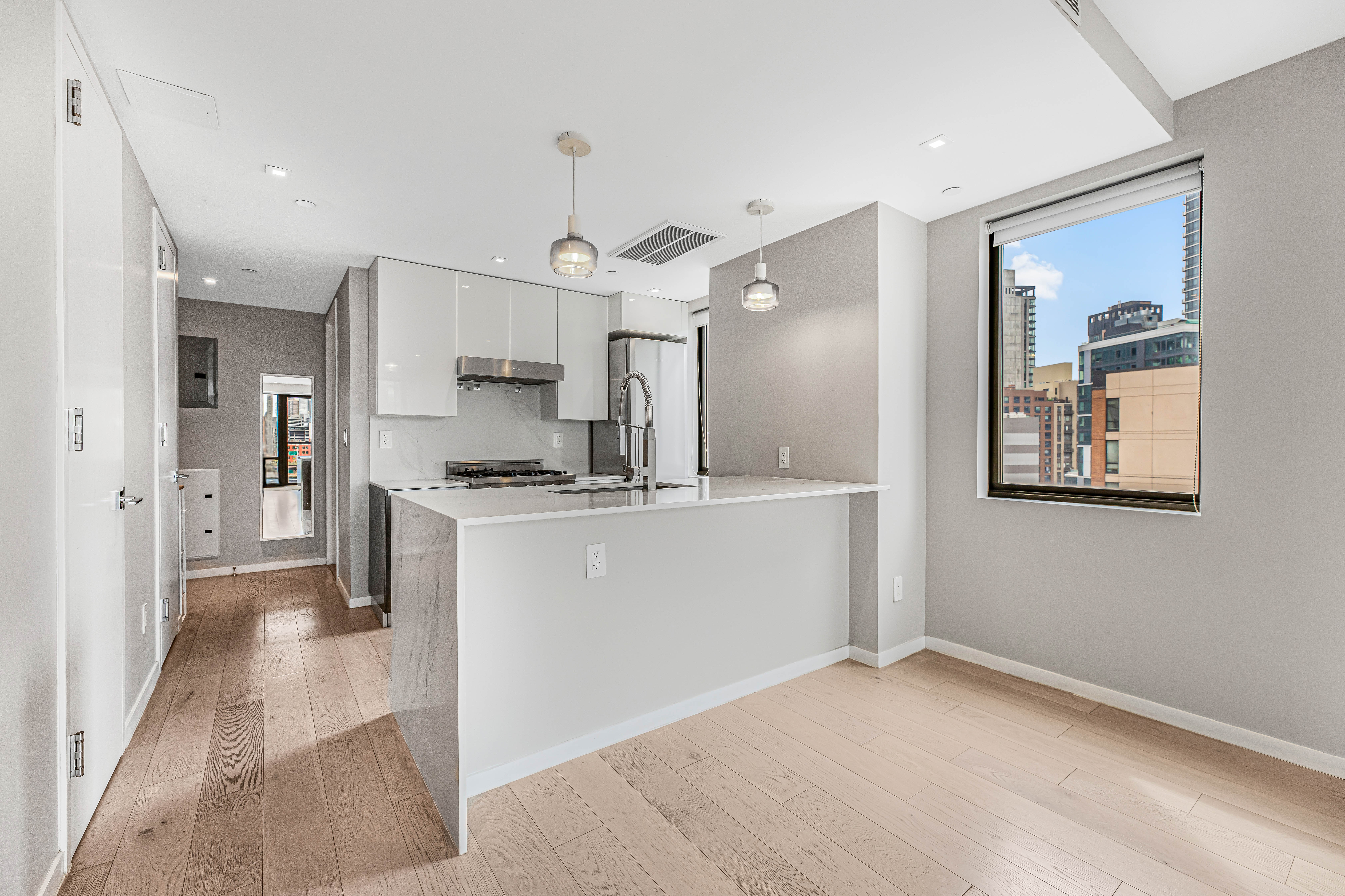 42-50 27th Street, Unit 9C Queens, NY 11101 - Photo 18 of 32 a view of kitchen with refrigerator microwave and stove