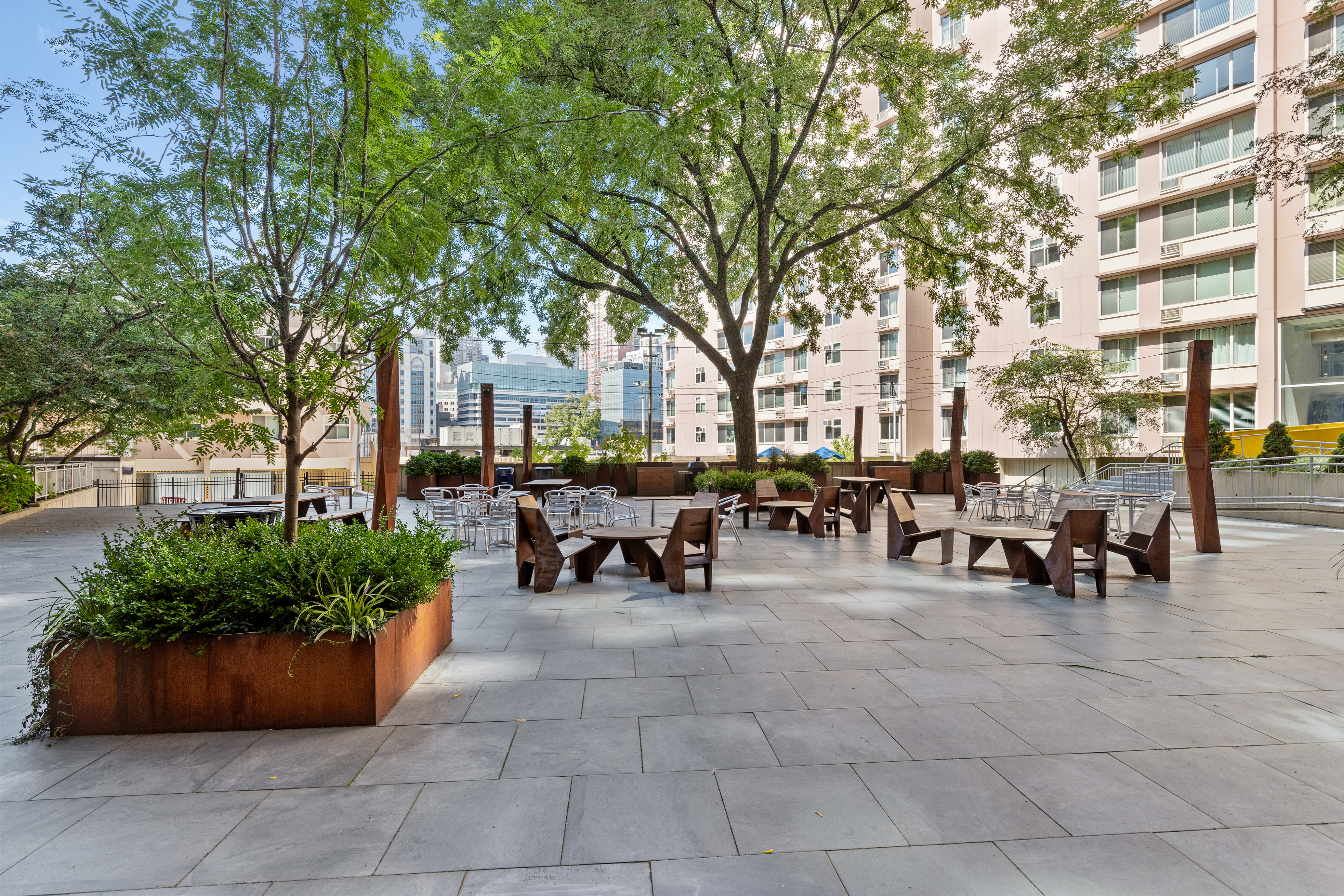 575 Main Street, Unit 1312 Manhattan, NY 10044 - Photo 18 of 25 a view of a patio with table and chairs and potted plants