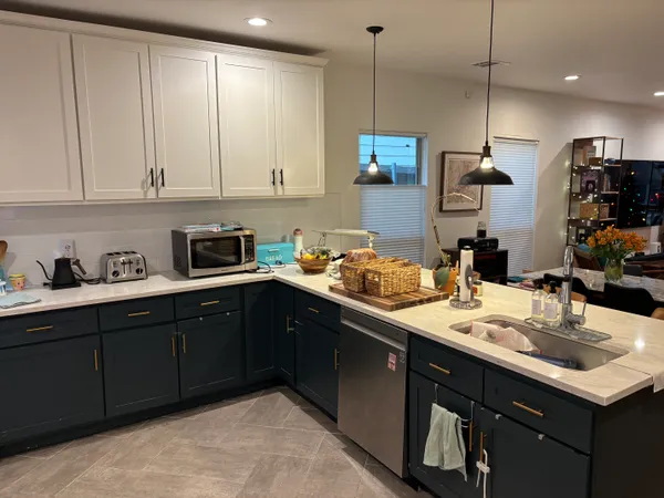 a kitchen with kitchen island granite countertop a sink a stove and cabinets