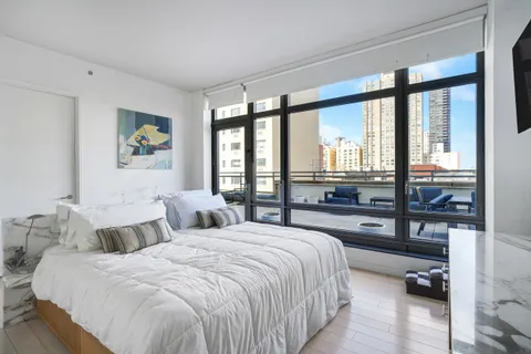 a bedroom with a bed and a large window