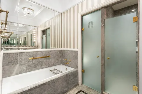 a bathroom with a tub a sink and mirrors