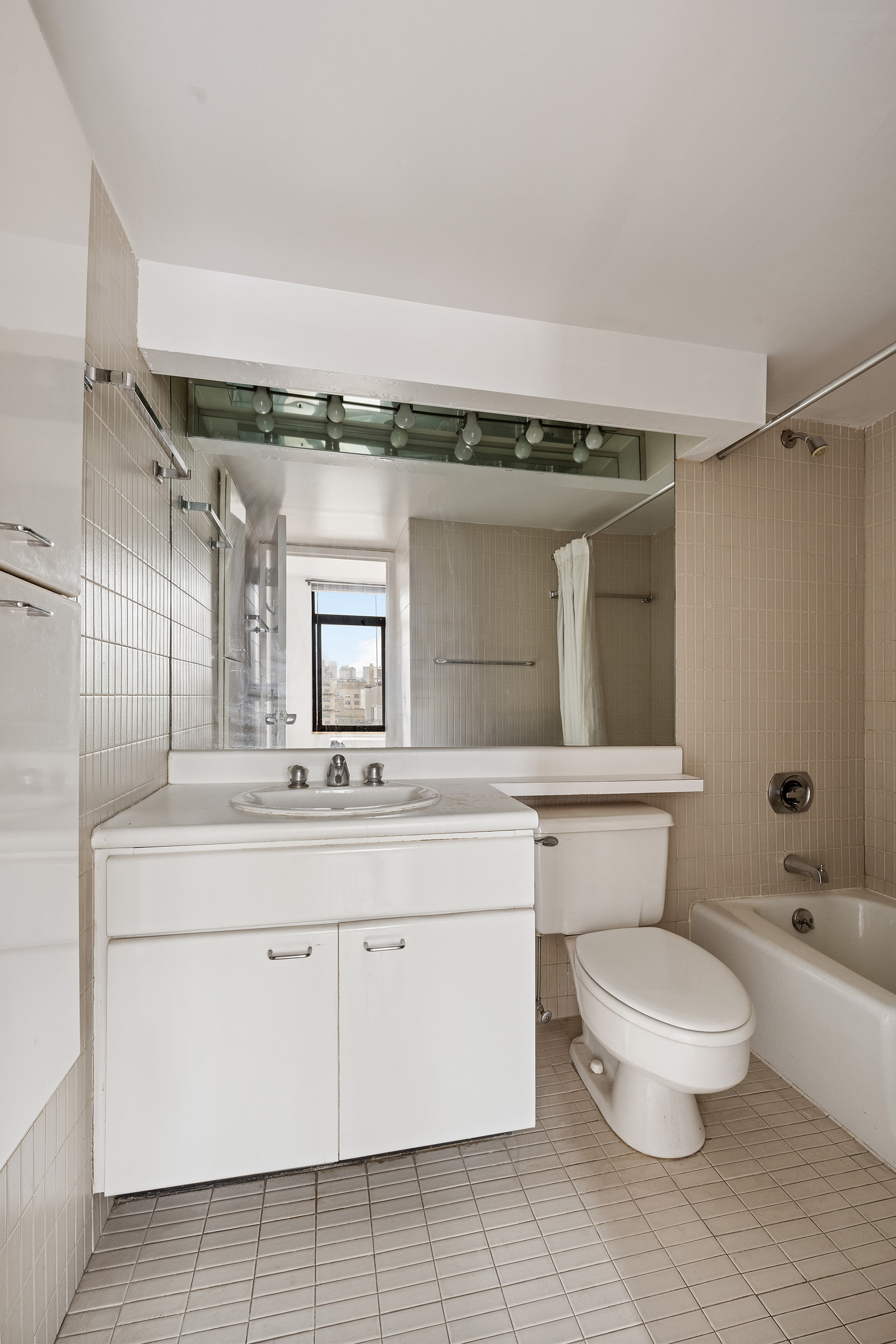 400 East 70th Street, Unit 1903 Manhattan, NY 10021 - Photo 5 of 6 a bathroom with a toilet sink and mirror
