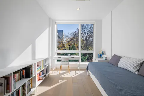 a living room with furniture a bookshelf and a large window