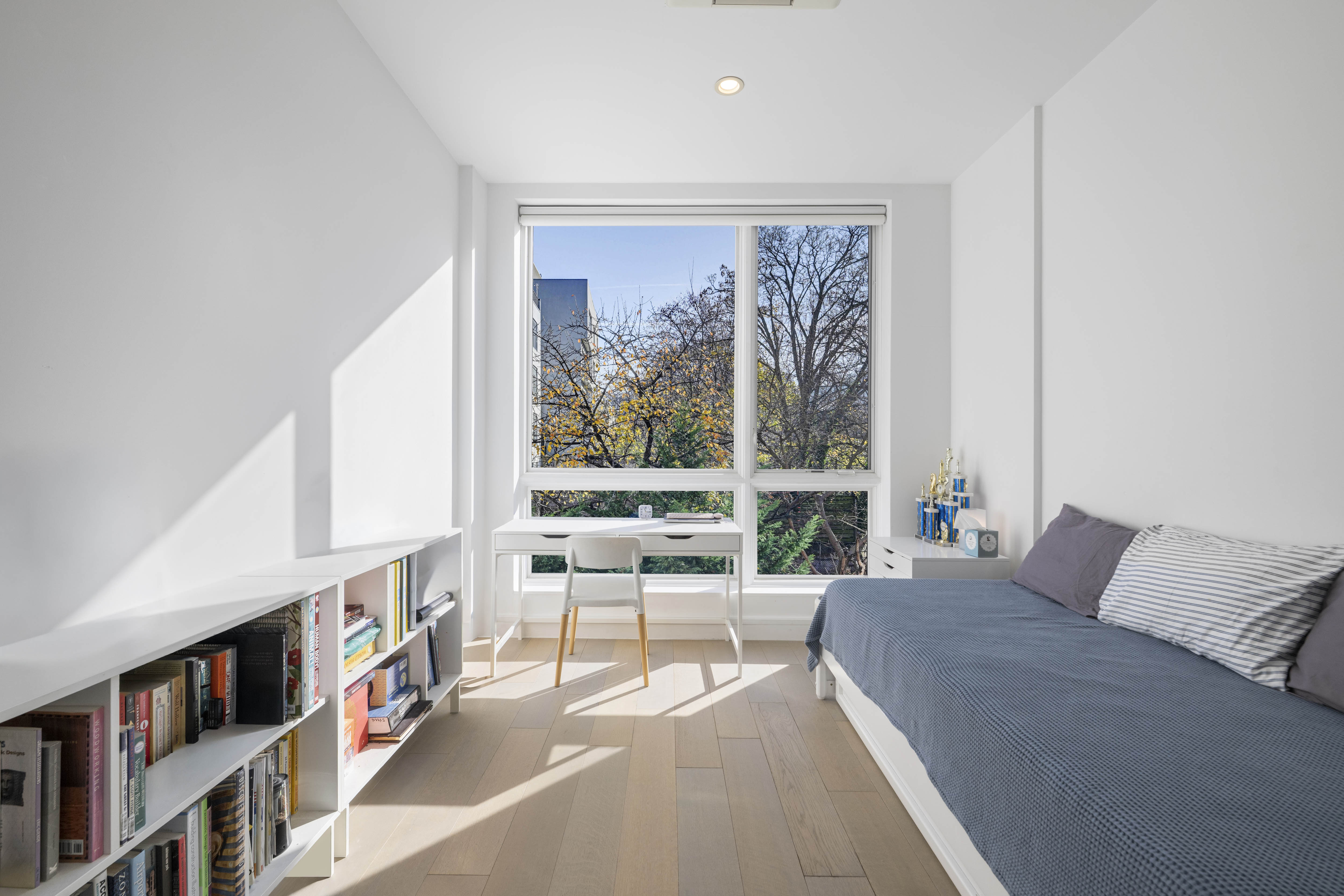 695 6th Avenue, Unit 2P Brooklyn, NY 11215 - Photo 7 of 15 a living room with furniture a bookshelf and a large window