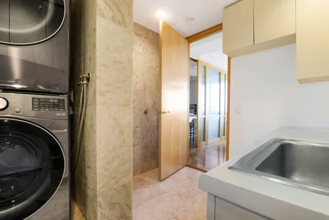 a view of a hallway with wooden floor and a bathroom