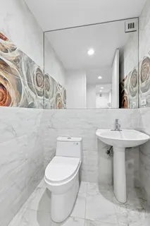 a bathroom with a toilet sink and mirror