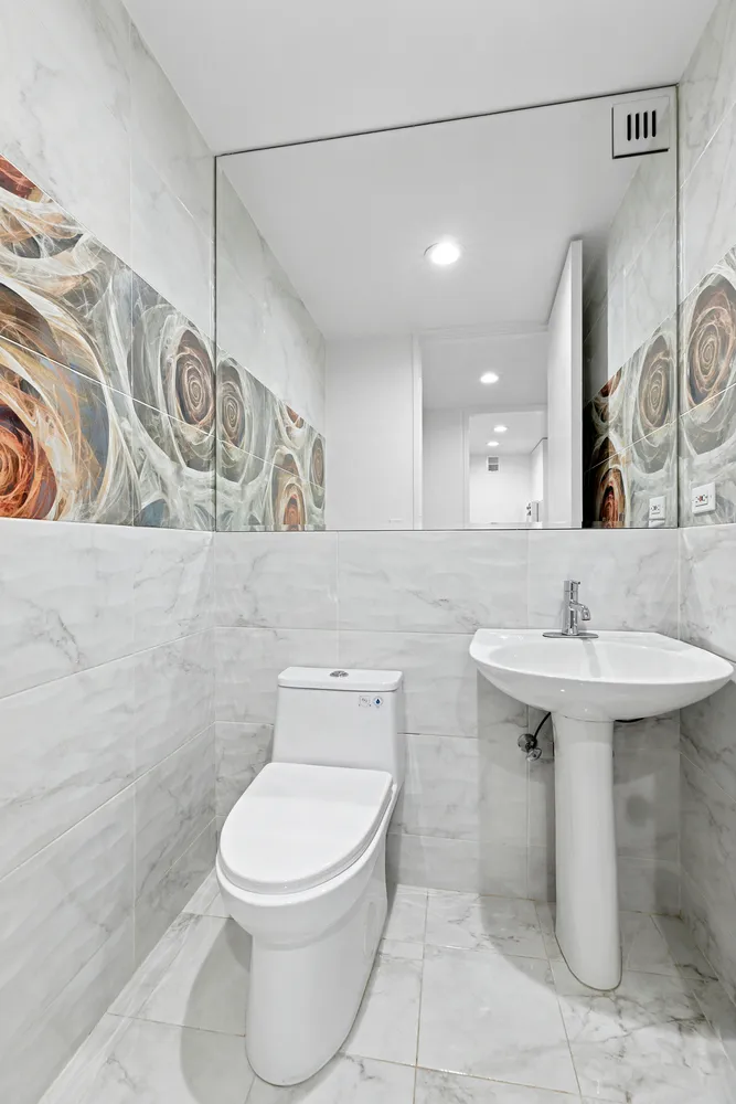 a bathroom with a toilet sink and mirror