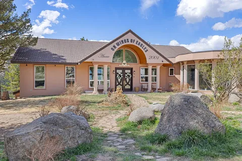 a view of a hallway with a dining table chairs and chandelier